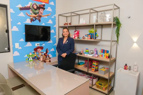 Kennya Martins na sala de psicologia infantil do Instituto Mundo de Dentro, entre a mesa e a estante de brinquedos